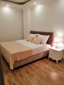 1 dormitorio con 1 cama y mesita de noche con lámpara en Căn hộ Sao Mai - Nội Bài Hà Nội, en Hanói