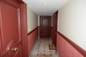 a hallway with red walls and a brown door at Résidence 3 Massena in Nice