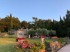 a garden with flowers in front of a building at Villa Le Polle di Meletro in Chianni
