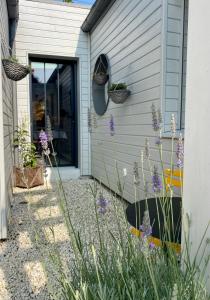 un jardin avec des fleurs violettes en face d'une maison dans l'établissement Douce Halte, à Sautron