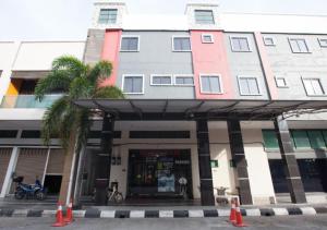 a building with a palm tree in front of a store at Hotel Pulai Ipoh in Ipoh