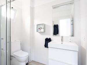 a white bathroom with a toilet and a sink at Live Medano Casanova frente a la playa in El Médano