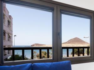 a room with a window with a view of the beach at Live Medano Casanova frente a la playa in El Médano