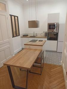 - une cuisine avec une table en bois dans une chambre dans l'établissement Appartement proche Gare Part-Dieu, à Lyon