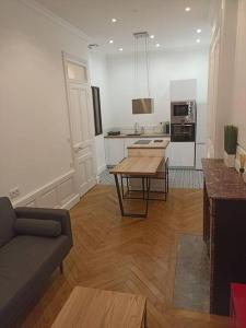 a living room with a table and a kitchen at Appartement proche Gare Part-Dieu in Lyon