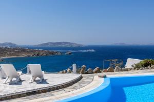 a pool with chairs and a view of the ocean at Seablue Villas in Houlakia