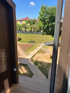 a door to a porch with a view of a park at Small apartment near city centre in Tartu