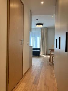 Cette chambre dispose d'un couloir avec une porte et un canapé. dans l'établissement Small apartment near city centre, à Tartu