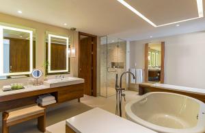 uma casa de banho com uma banheira grande e um lavatório em The Westin Cozumel em Cozumel
