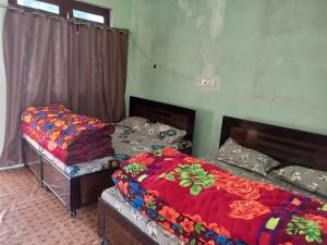 two twin beds in a room at Aditya guest House and restaurant in Trijugi Nārāyan
