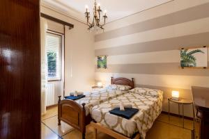 a bedroom with a bed with a striped wall at Appartamento Ducco zona ospedale in Brescia