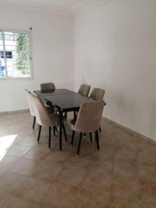 Appartement luxueux à Rabat في الرباط: طاولة طعام سوداء وكراسي في غرفة