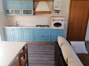 una cucina con armadi blu e un divano di Nido sul Garda a Castelnuovo del Garda