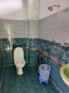 a bathroom with a toilet and a sink at Aditya guest House and restaurant in Trijugi Nārāyan