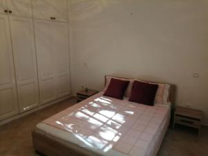 Appartement luxueux à Rabat في الرباط: غرفة نوم بسرير كبير ومخدات حمراء