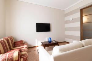 a living room with two white couches and a tv at Appartamento Ducco zona ospedale in Brescia