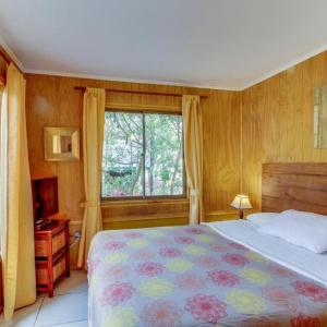 Un dormitorio con una cama grande y una ventana en AmbienteMar Cabañas, en Papudo