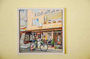 a painting of a bike in front of a building at Edelvais Guest House in Primorsko