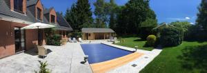 a swimming pool in a yard next to a house at Villa Sparadis in Spa