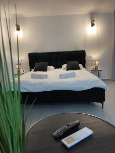 1 dormitorio con 1 cama con 2 mandos a distancia en una mesa en K.suites סוויטות בוטיק, en Beit She'an