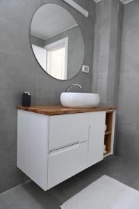 W łazience znajduje się biała umywalka i lustro. w obiekcie K.suites סוויטות בוטיק w mieście Bet Sheʼan