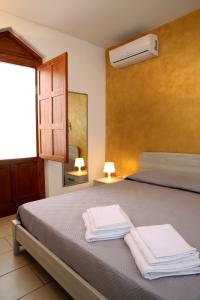 een slaapkamer met een bed met twee handdoeken erop bij Corte Rondine B&B in Presicce