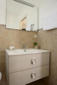 een badkamer met een wastafel en een spiegel bij Corte Rondine B&B in Presicce