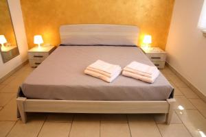 ein Schlafzimmer mit einem Bett mit zwei Handtüchern darauf in der Unterkunft Corte Rondine B&B in Presicce