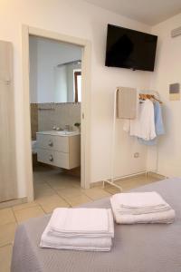 een badkamer met een bed, een wastafel en een spiegel bij Corte Rondine B&B in Presicce