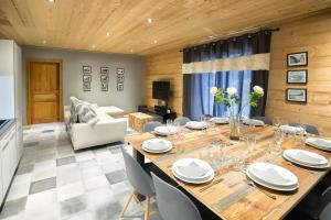 een eetkamer met een grote houten tafel en stoelen bij HaKaJu Appartement 10 personnes à Val Cenis in Lanslebourg-Mont-Cenis