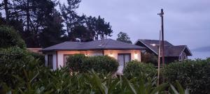 una pequeña casa con luces en la parte delantera en AmbienteMar Cabañas en Papudo