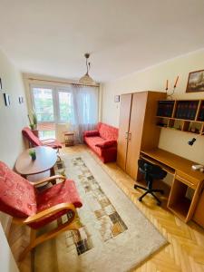 a living room with a red couch and a desk at Okrzei 15 - poczuj się jak w domu in Sopot