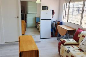 een woonkamer met een koelkast en een bank bij Appartement à Empuriabrava in Empuriabrava