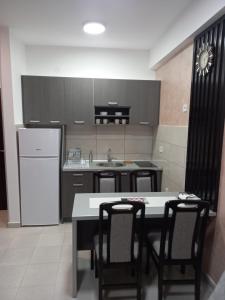 cocina con mesa, sillas y nevera en Stojanović apartman Jagodina, en Jagodina