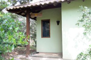 uma pequena casa branca com uma pequena janela em Villa Severina em Brumadinho