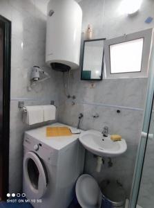 a small bathroom with a toilet and a sink at Apartmani Fortunela in Sveti Stefan