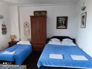 a bedroom with two beds with blue sheets and a cabinet at Apartmani Fortunela in Sveti Stefan