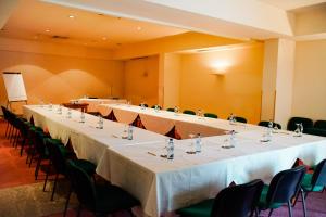 Hotel Premium Porto Maia في مايا: صف من الطاولات الطويلة في غرفة مع الكراسي