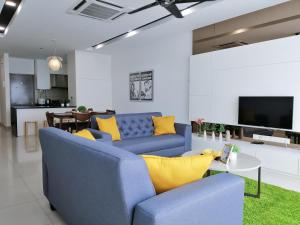 吉隆坡的住宿－Setapak Central Signature Suites by Manhattan Group，客厅配有蓝色的沙发和黄色的枕头。