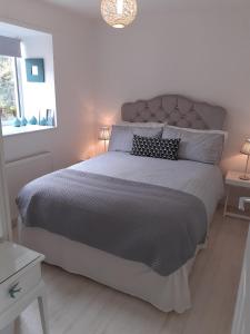 a bedroom with a large bed with a gray comforter at Castlefield Cosy Cottage in Cupar