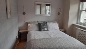 a small bedroom with a bed and a mirror at Castlefield Cosy Cottage in Cupar