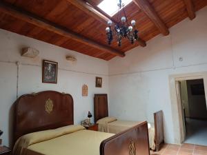 a bedroom with a bed and a chandelier at Agriturismo Giannavi in Palazzolo Acreide