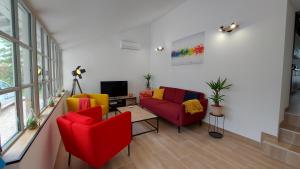 een woonkamer met kleurrijke stoelen en een televisie bij Soleil Blaisois in Blois