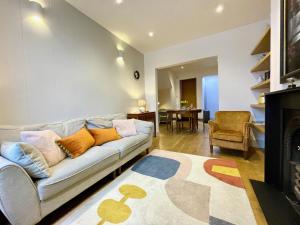 a living room with a couch and a fireplace at Stylish 2-bedroom Townhouse next to Brighton Station in Brighton & Hove