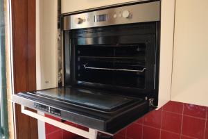 a black oven sitting inside of a kitchen at Appartement Dans un Terrain de Golf, 5 min de la mer en Voiture, Parking Gratuit in Cogoleto