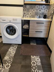 una lavadora y secadora en una pequeña cocina con azulejos en Douai 2: joli appartement face à la gare, en Douai
