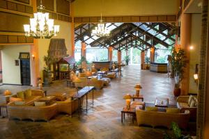 eine große Lobby mit Sofas und Tischen in einem Gebäude in der Unterkunft Toraja Heritage Hotel in Rantepao