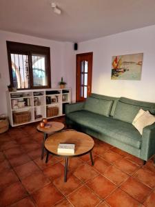 una sala de estar con un sofá verde y mesas. en B&B Casa Mijo, en Daimalos