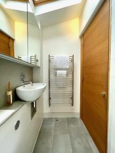 uma casa de banho com um lavatório e um espelho em Stylish 2-bedroom Townhouse next to Brighton Station em Brighton & Hove