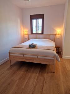 1 dormitorio con 1 cama grande y suelo de madera en B&B Casa Mijo, en Daimalos